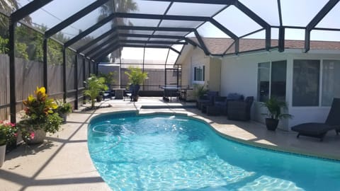 Large expansive pool deck with 3 seating areas, large grill and table tennis.