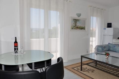 Living room with sofa bed, kitchen and dining area.