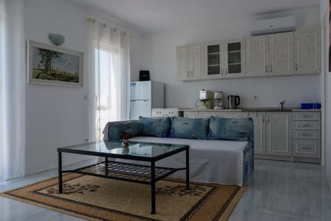 Living room with sofa bed, kitchen and dining area.