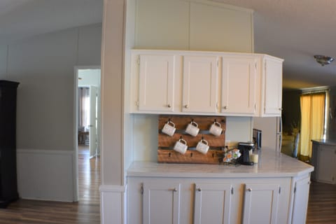 coffee station with Rae Dunn mugs and pod style coffee maker