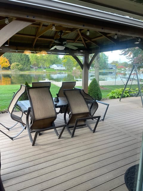 Gazebo with ceiling fan and lights on deck with 6 person table and chairs.