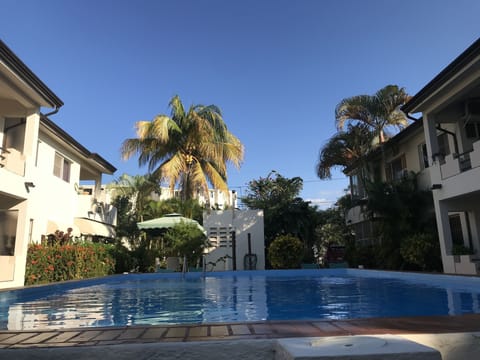 Pool with lounge chairs, a table  a few regular chairs plus a charcoal fed bbq 