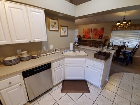 Large fully equipped kitchen with pots, pans, flatware, cups and glasses.