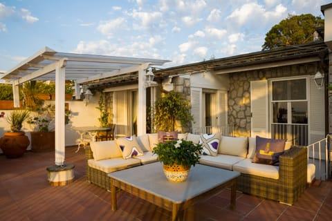 Comfortable sofa with large stone table on terrace