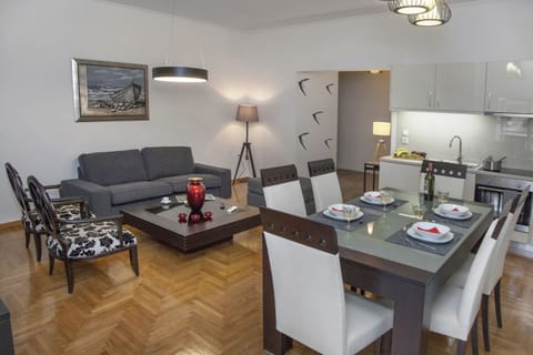 The living room with the open plan kitchen and the dining table