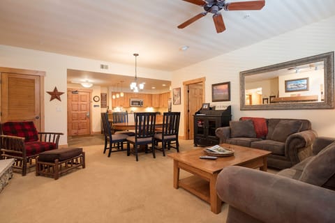 Relax in your spacious living area with plush seating, rustic wood touches, and open-concept kitchen perfect for memorable gatherings.