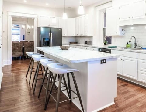 The custom, fully equipped chef’s kitchen with a marble top breakfast bar