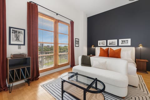 Bright and airy bedroom with floor-to-ceiling windows and a cozy modern vibe.