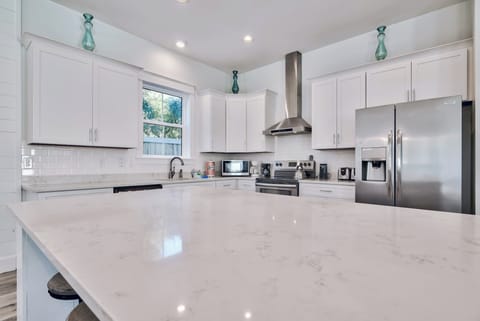 Sleek kitchen w/ bright finishes & ample prep space.