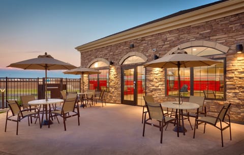 Outdoor patio seating area with tables and umbrellas.
