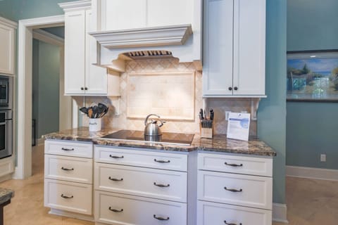 The kitchen features an electric cooktop with hood.