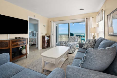 Living area with a sectional and ocean views through sliding doors at Sand Trap Villas C1, a 4-bedroom Cherry Grove rental