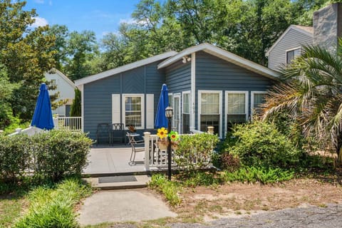 Blue cottage with a patio, umbrellas and potted plants at Blue Atlantic, a 4-bedroom Ocean Drive vacation rental