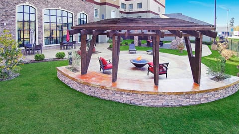 Gather around the fire pit beneath the stylish pergola, ideal for cozy evenings and great conversation.