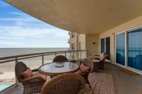 Spacious oceanfront balcony with cozy seating and stunning views