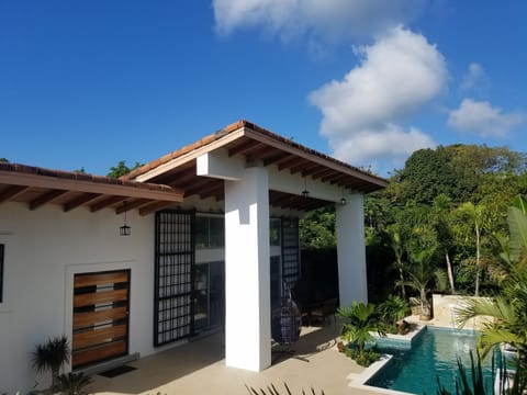 villa featuring swimming pool, impressive columns, and a high roof