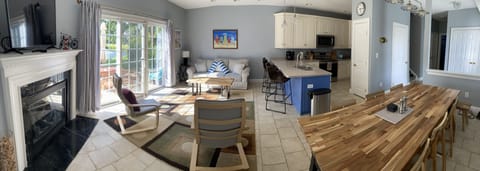 Panoramic view of living, dining areas & kitchen. Sliding door opens to patio.