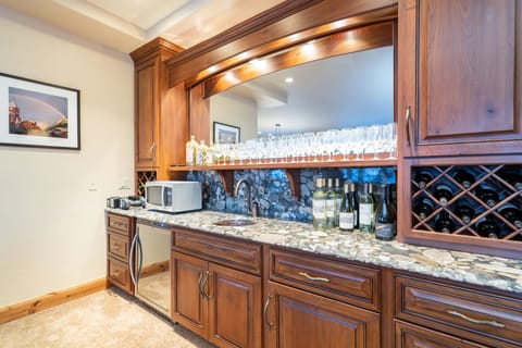 Private wet bar with plenty of glasses and drink options.