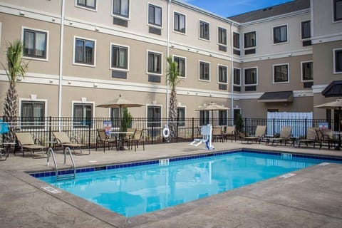 Take a dip in the crystal-clear pool surrounded by comfortable lounge chairs for ultimate relaxation.