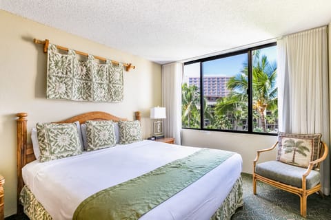 Sink into crisp linens in your island-inspired bedroom, where lush palm trees and city views greet you through the window each morning, creating a serene tropical escape.