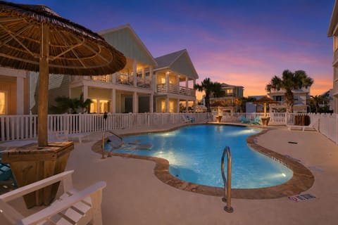 Resort Pool at Sunset — Freeform Pool with Tiki Umbrellas, Pink & Purple Sky