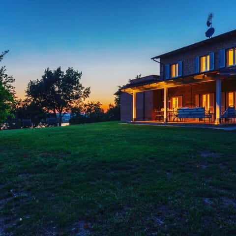 Side view of covered patio and yard overlooking lake and sunset.
