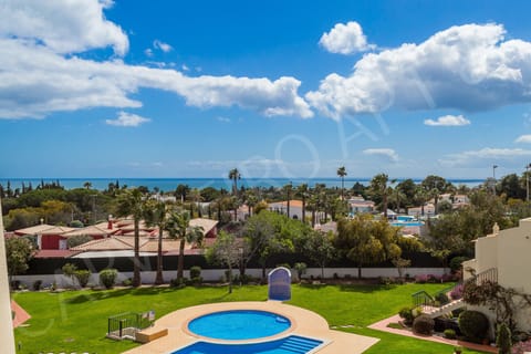 Communal swimming pool at Carvoeiro Apartment 8A complex surrounded by palm trees and landscaped gardens, a refreshing oasis in this gated residential development close to Carvoeiro centre