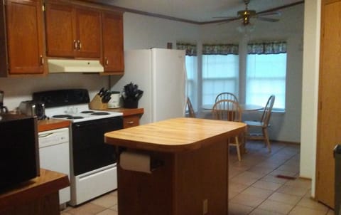 Kitchen with electric stove, refrigerator, dishwasher & microwave.