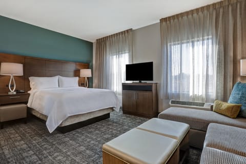 Studio bedroom with queen bed, TV, and seating area.