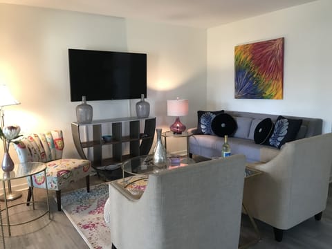 Colorful, clean, and bright living room with flat screen TV.
