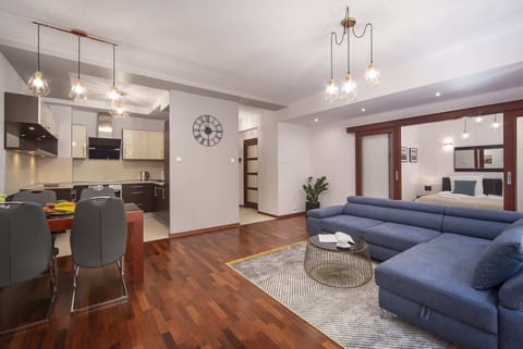 Living room showcasing the large sectional sofa, coffee table, and natural light from the windows.