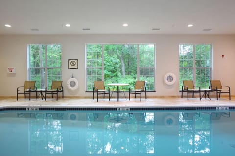 Indoor pool area with poolside seating and garden views.