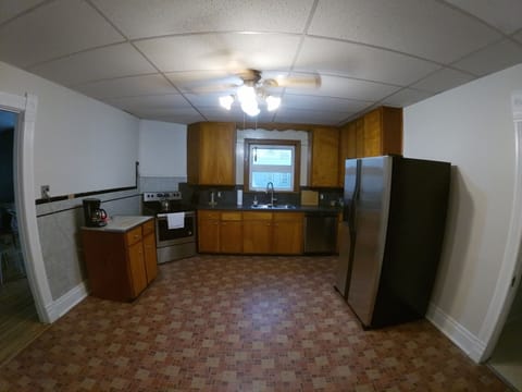 Large kitchen with stainless steel appliances, microwave, coffee maker.