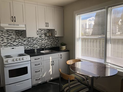 Stove/oven, sink, cooking supplies.  Small kitchen table.  Mini-fridge.