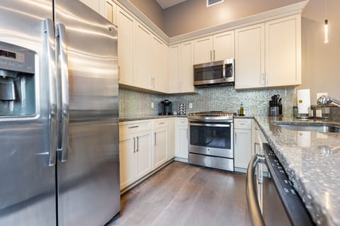 Cook and dine easily in the fully stocked kitchen, equipped with all stainless steel appliances, gas range, basic cookware, and a dining area for a comfortable meal at home. Entertain at the bar with seating for four.