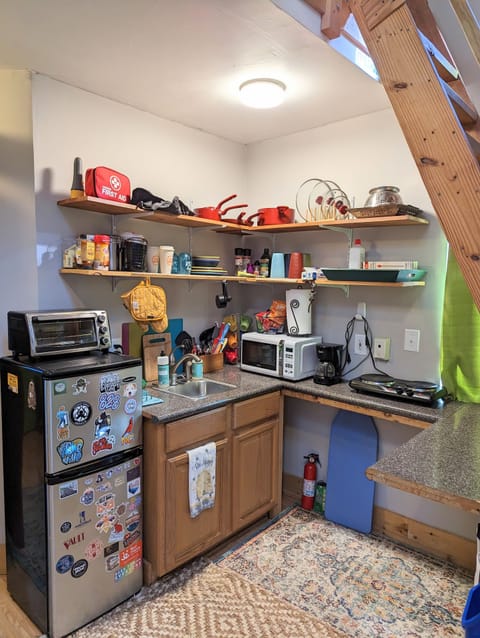 Fridge/freezer, toaster oven, microwave, double burner, coffee pot, & dishes