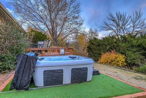 Backyard hot tub set on a tidy turf pad—sink in for a steamy soak while trees frame the sky, then step out to fresh air and quiet surroundings.