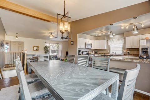 Open dining and kitchen flow—serve up meals from the nearby island, pull up bar stools for snacks, and linger at the long table under the modern chandelier as the room stays bright and social.