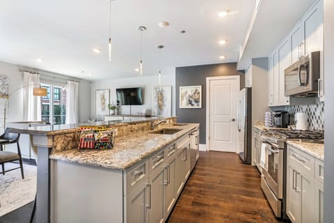 Cook and dine easily in the fully stocked kitchen, equipped with all stainless steel appliances, gas range, basic cookware, and a dining area for a comfortable meal at home. Entertain at the island with seating for four.