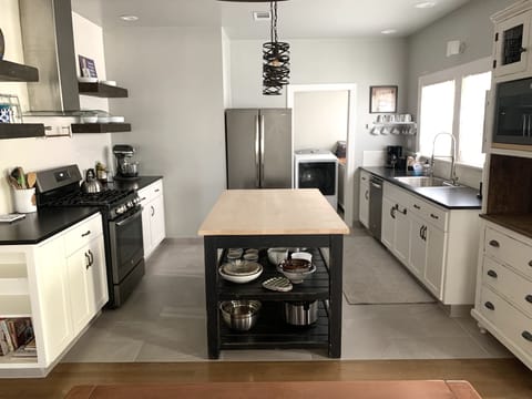 Kitchen with butcher-block island, gas stove/oven, microwave & Mr. Coffee.