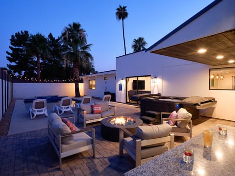 Large private resort-like backyard featuring a sparkling blue pool, hot tub, fire pit, BBQ grill, plenty of outdoor seating, and a built-in bar.