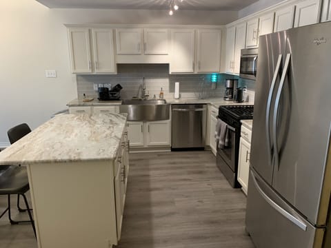 Refrigerator with ice maker, stainless farmhouse sink, glass tile backsplash