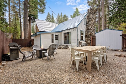 Back yard complete with seating around a propane fire pit and a grill.