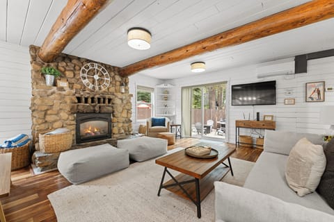 Stone fireplace, wood beams, and stylish lake mountain decor. 