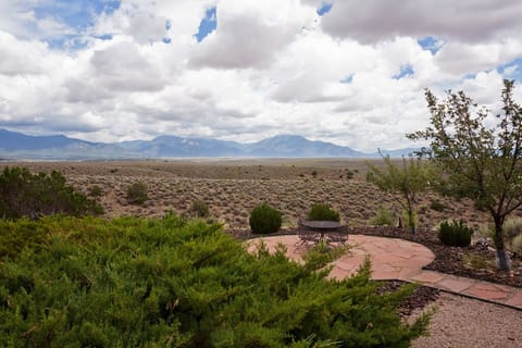 View of the Sangre de Christos Mountains and lower patio with table and chairs.