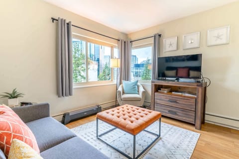 This inviting living room boasts stylish leather furniture, a spacious coffee table, and a flat-screen TV for relaxation. 