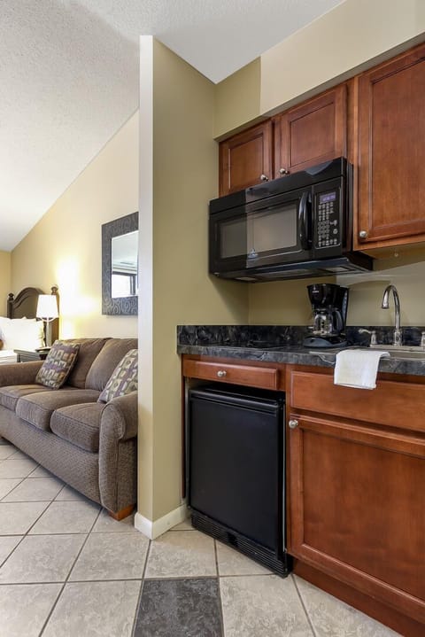 The unit features a small kitchen equipped with a coffee maker and a mini fridge for your convenience.