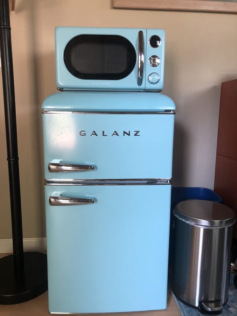Refrigerator stocked with yogurt, fruit,  milk, dairy and non-dairy creamer.
