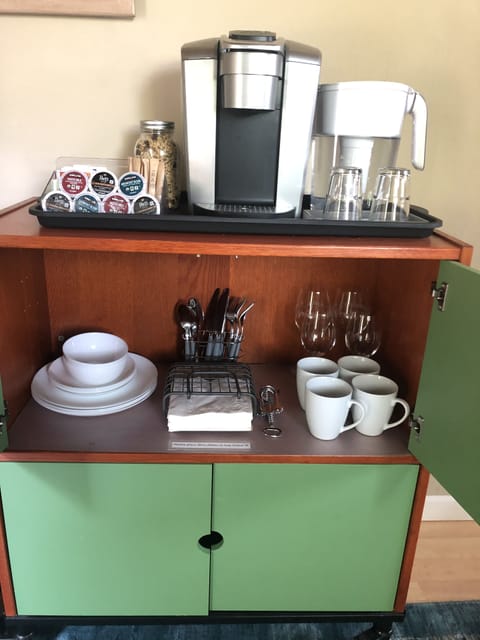 Keurig, generous assortment of pods and teas, granola, water, tableware.
