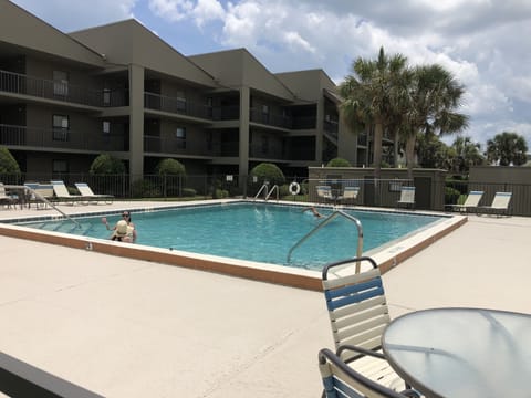 Seawatch's private pool with lounge chairs and tables already setup  